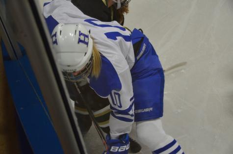 Kylie Hanley, freshman, battling for the puck against the board in Thursday's win.