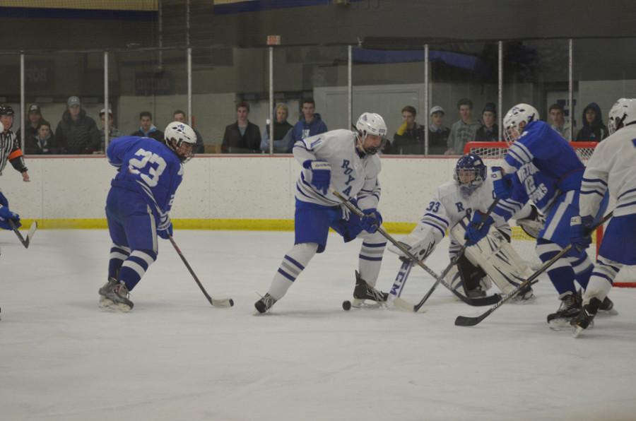 Hunter Staack, junior, tries to slap away the puck as Josh Kuehmichel, senior, defends the goal. 