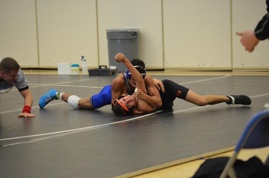 Nate Johnson, sophomore, puts Minneapolis South wrestler in an armlock.
