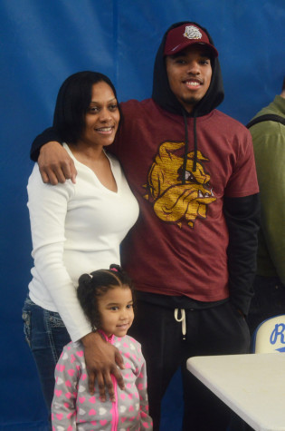Bill Atkins, senior, poses with his family after signing.
