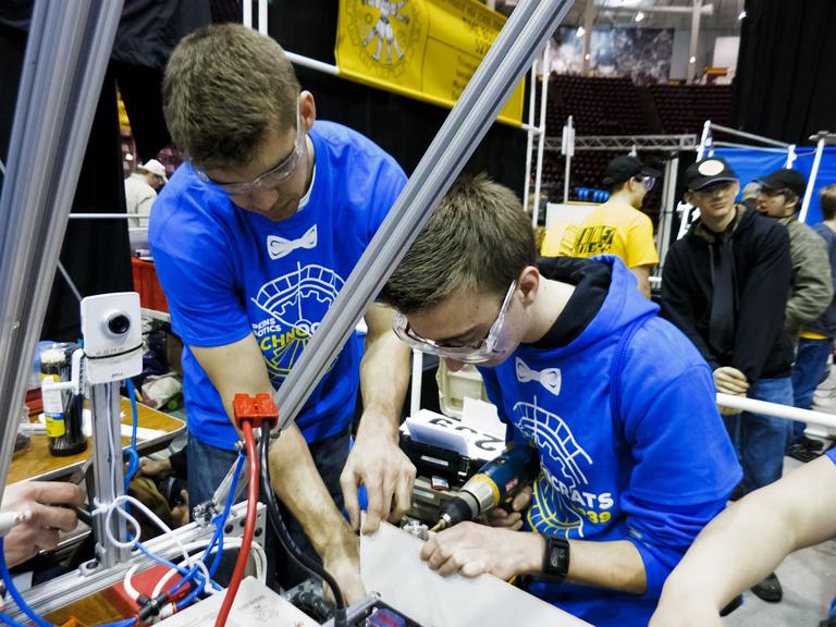Dan Pratt, junior, and Chris Halvorsan, mentor, work on robot.
