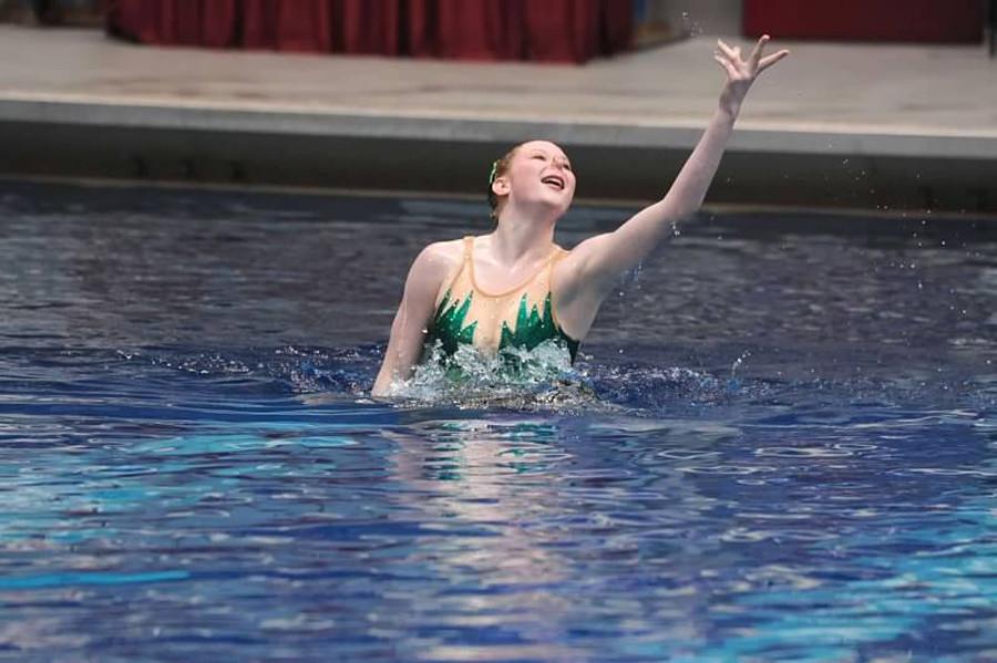 Maggie Cleary, senior, rises above the water in her synchronized swimming routine. 