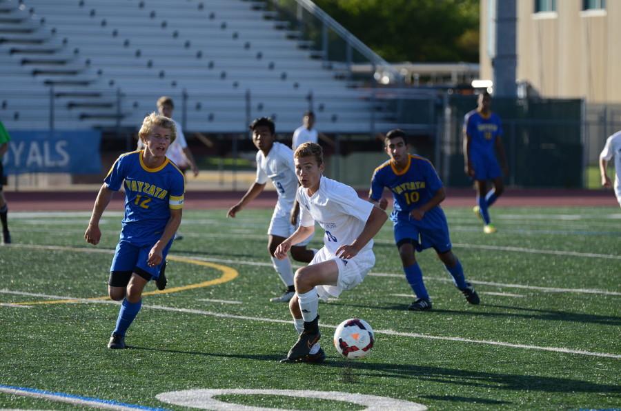 Alex Swenson, senior, chases the ball in the game against the Wayzata Trojans.