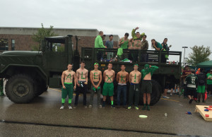 Senior boys pose in front of the army truck.