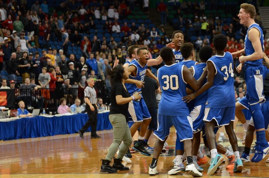 The HHS boys basketball team storms the court after the state championship win.