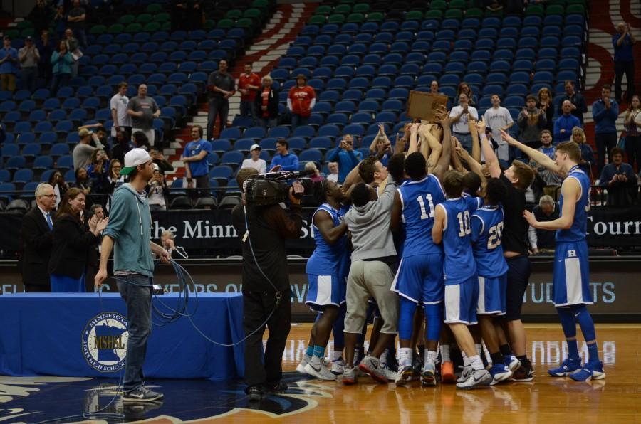 The HHS boys basketball team celebrates with their trophy after the AAAA state championship win.