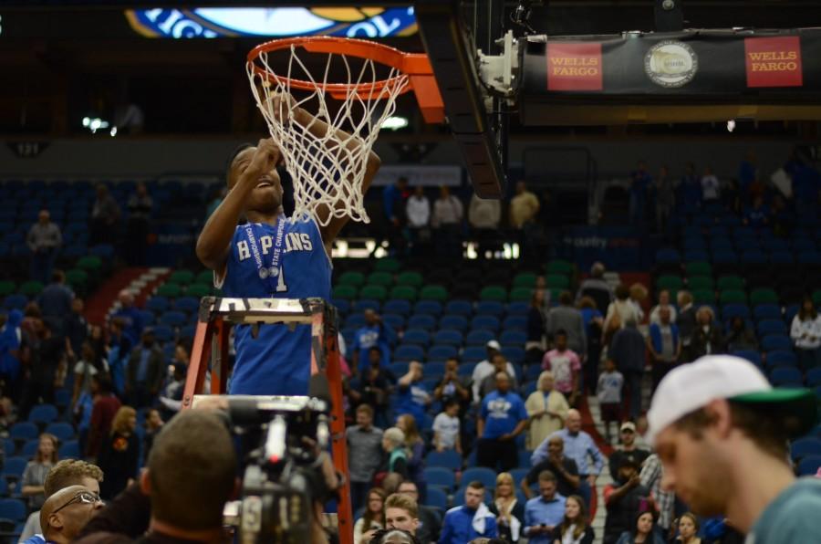 Xavier Johnson, senior, cuts his part of the net after the AAAA state final game.