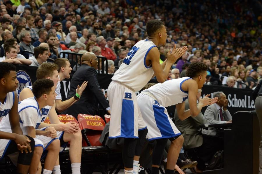 The players on the bench cheer on their teammates during the semifinal state game against Apple Valley.