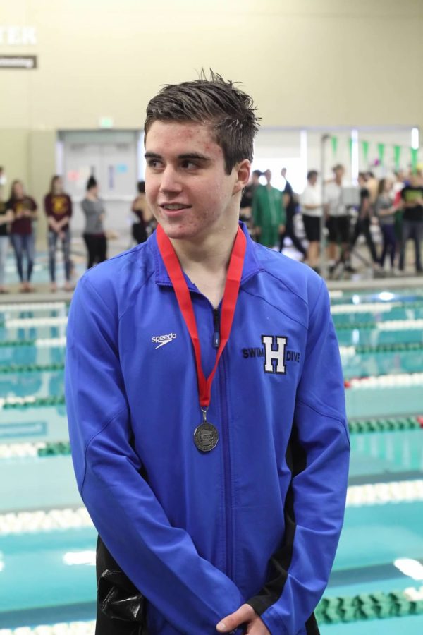 Avery Martens-Goldman, junior, stands with his second-place medal at the section finals meet. Martens-Goldman placed second in the 200 IM and the 100 breaststroke, qualifying for the AA state meet in both events.