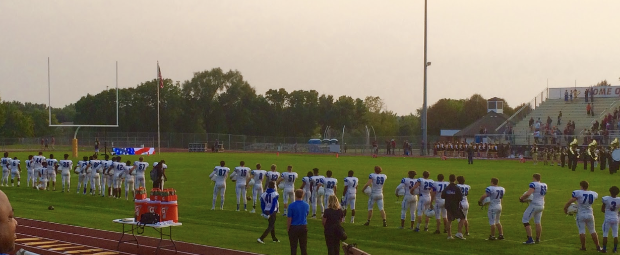 The Royals football team rises for the national anthem during their game against the Eden Prairie Eagles. The Royals lost this game 7-27.