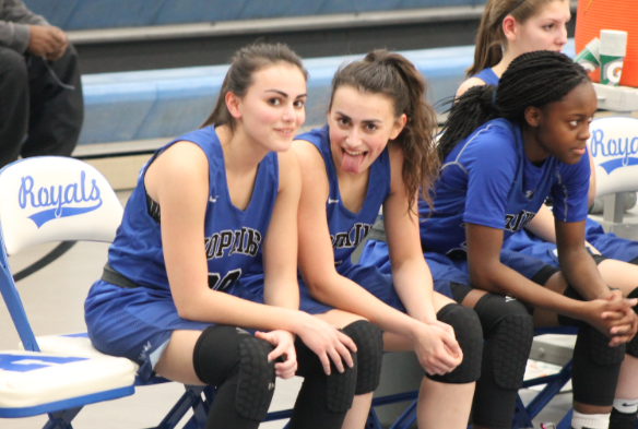 Tehmi Bozicevich, sophomore, sits next to her sister, Asha Bozicevich, HHS alum during Royals basketball game. 
