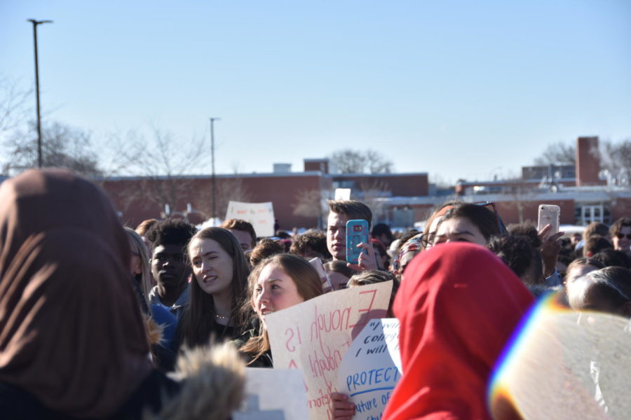 Members of the crowd chant, record, and rally for change during the walkout.