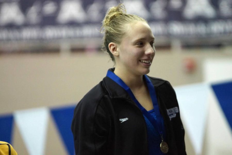 Susanna Fish, junior, on podium after winning section title in diving. Fish qualified for state.
