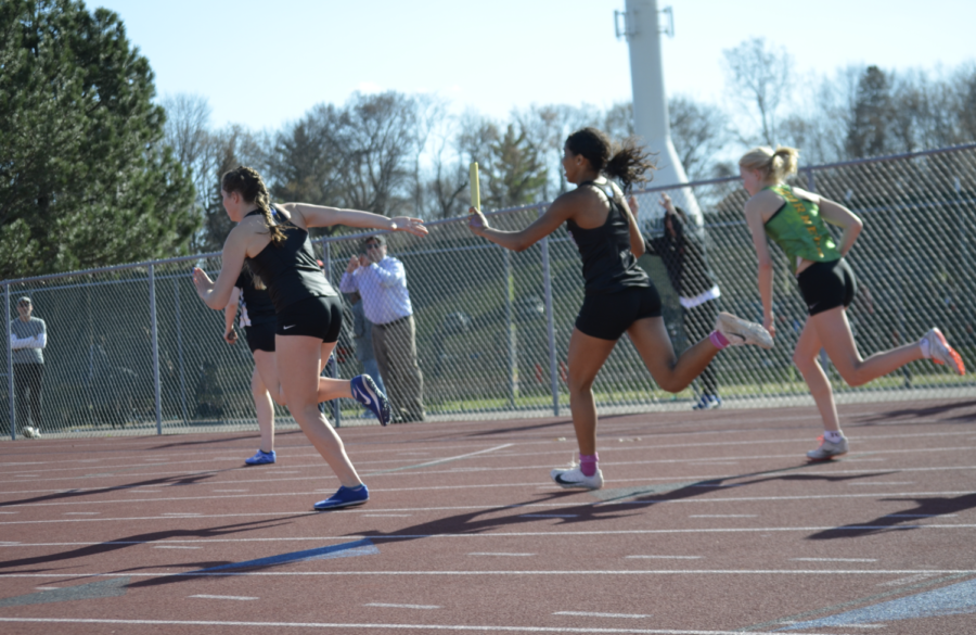 Alayna Contreras, freshman, hands off the baton to Sally Reed, senior, at the True Team Invitational