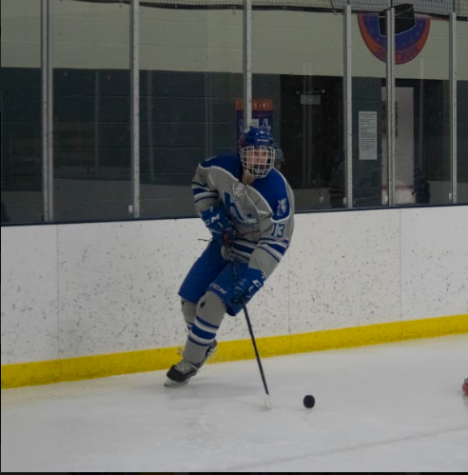 Dominic Valentini, junior skates around his net with the puck. Valentini has proven to be a offensive threat on the Hopkins boys varsity team.